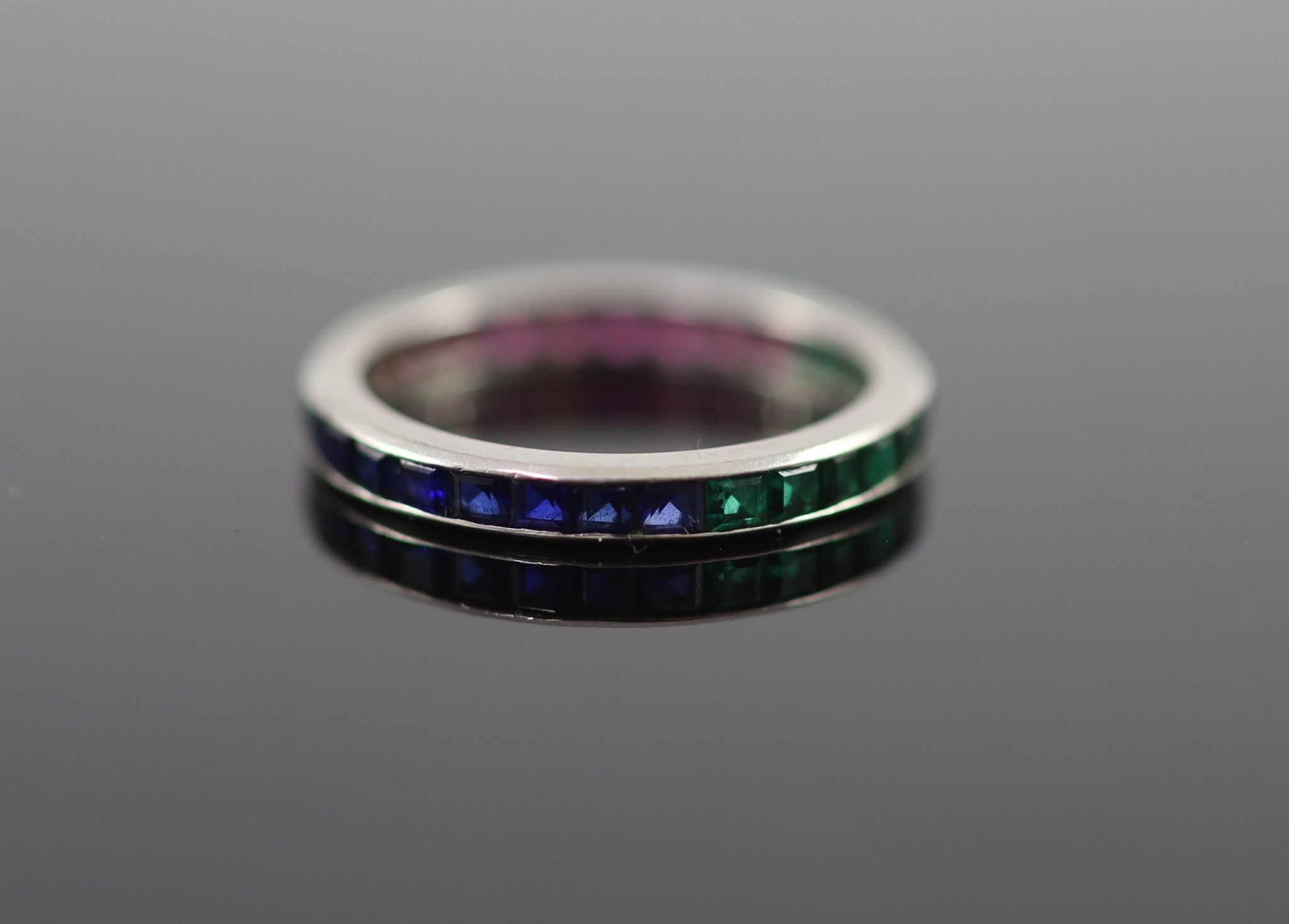A platinum? ruby, emerald and sapphire set full eternity ring